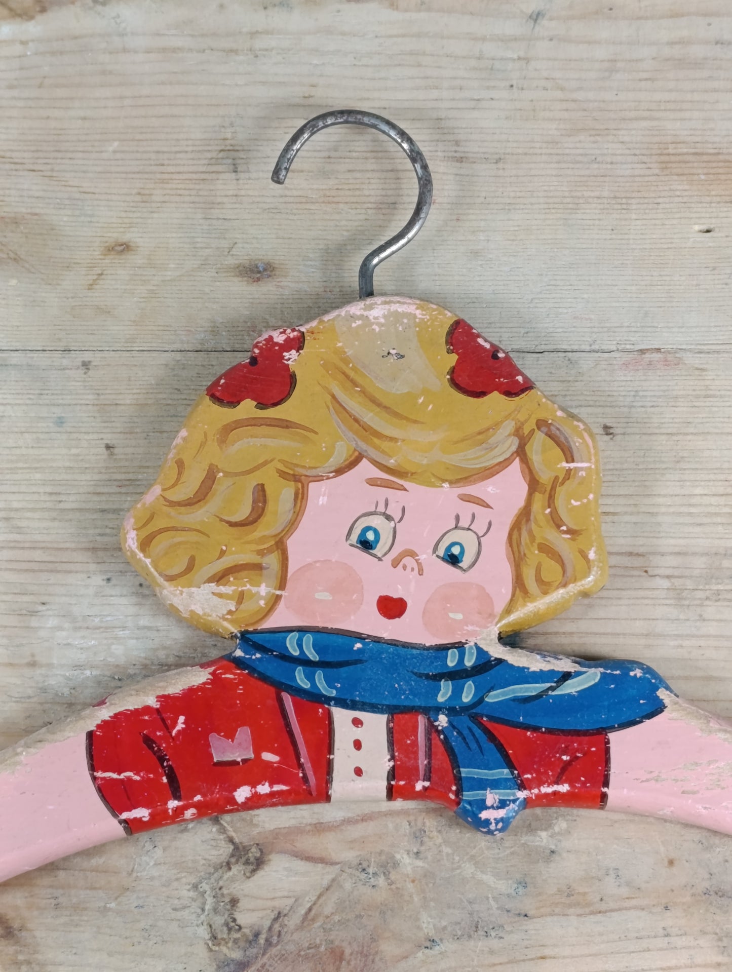 Percha de madera pintada a mano de la tienda Mariquita Pérez para vestidito de niña